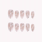 Odette’s Pearl Wing: sheer pink press-on nails with pearly wing-like textures and small gem accents, arranged on a pale background.