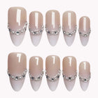 Chiffon Pearl Halo nude almond nails with pale translucent tips edged in silver-colored beads and clear gems.