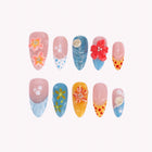 Oceania’s Floral Crown: blue, pink and orange almond press-on nails with raised flowers and shell accents, arranged on a pale background.