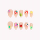 Tutti Frutti Daydream: nude almond press-on nails with colorful raised fruit and citrus-slice decorations, arranged on a pale background.