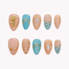 Thalassa's Golden Rose nude and aqua almond nails with raised gold-colored floral details and iridescent oval accents.