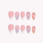 Pearl of Atlantis: pink and lavender press-on nails with white tips, shell ridges and gold accents, arranged on a pale background.