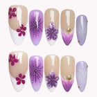 Lunar Orchid nude, white and purple almond nails with dark pink flowers, a raised lavender flower and fine radiating lines.