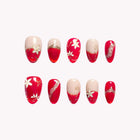 Scarlet Petal Dynasty: red and nude almond press-on nails with white flowers and gold-tone curved accents, set arranged on a pale background.