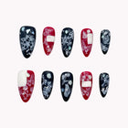 Obsidian Butterfly Spell black and red almond nails with white butterfly, floral and bow-like patterns.