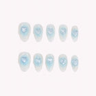 Glacial Heart Reverie: pale blue and white almond press-on nails with raised blue hearts, arranged on a pale background.