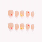 Spring Sprite French: nude almond press-on nails with white French tips and small pink and yellow flowers, arranged on a pale background.