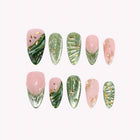 Titania’s Emerald Wing: green and nude almond press-on nails with gold-toned lines and leaf-like patterns, arranged on a pale background.