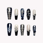 Midnight Rosary Lace: long black and nude coffin press-on nails with lace patterns, lattice lines and silver-tone jewels, set arranged on a pale background.