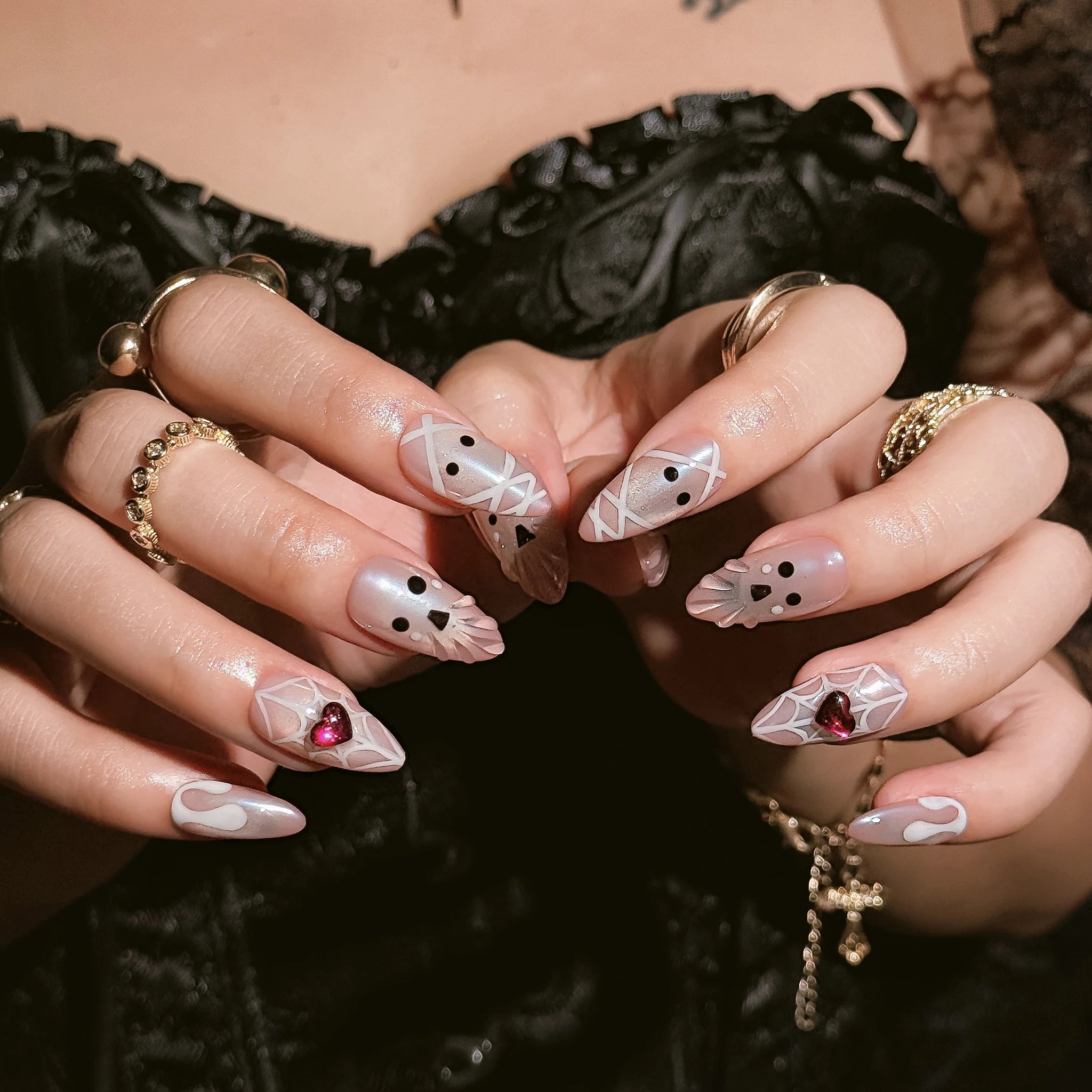 Blushing Phantom Heart press-on nails worn on both hands in a styled lifestyle setting