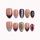 Chimera’s Amber Mosaic medium almond press-on nails with tortoise, grid, and dotted French tip designs on white.