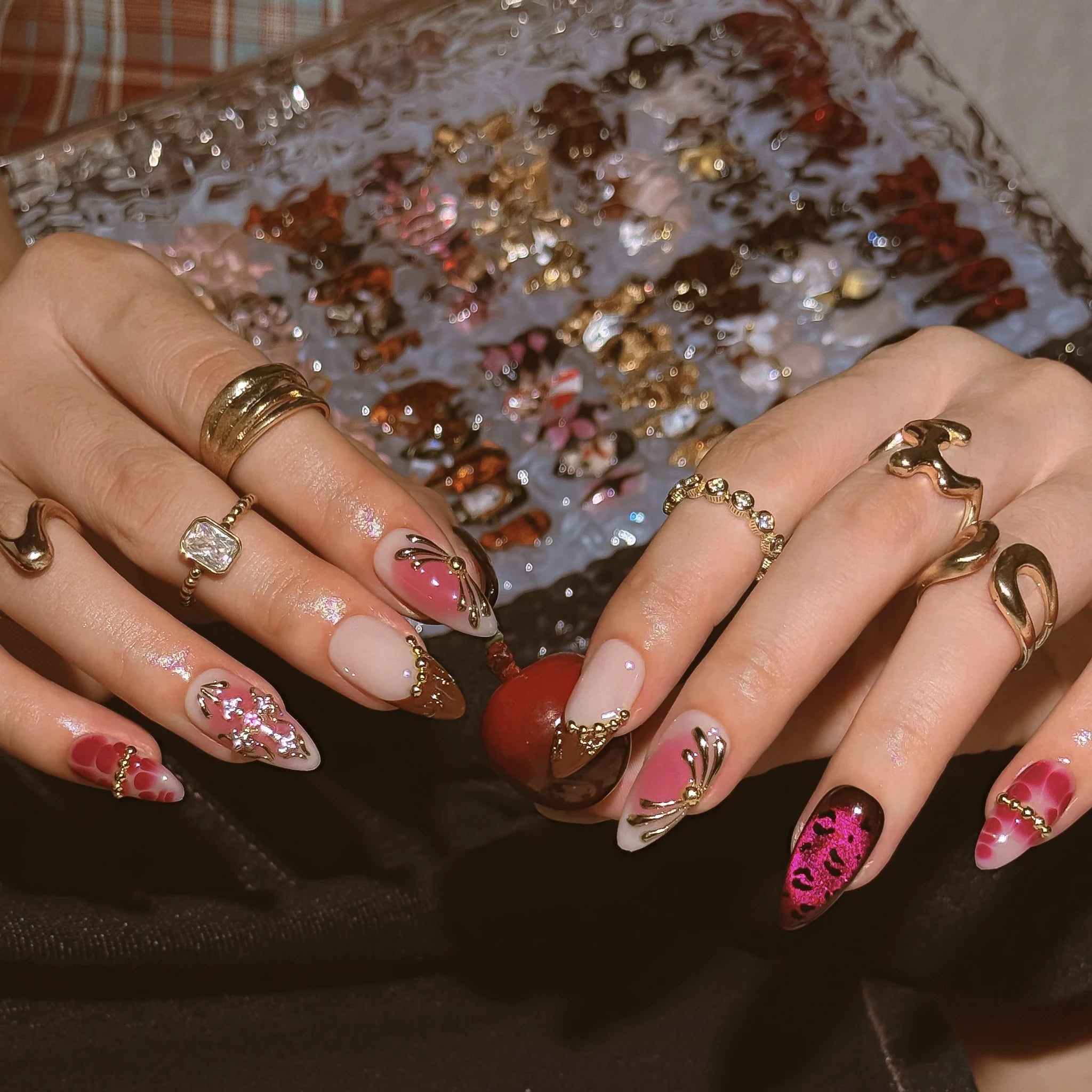 Crimson Rosary Bloom press-on nails worn on both hands in a styled lifestyle setting