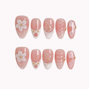 Galatea’s Ivory Bloom short almond press-on nails with pink French tips, raised flowers, and pearl details on white.