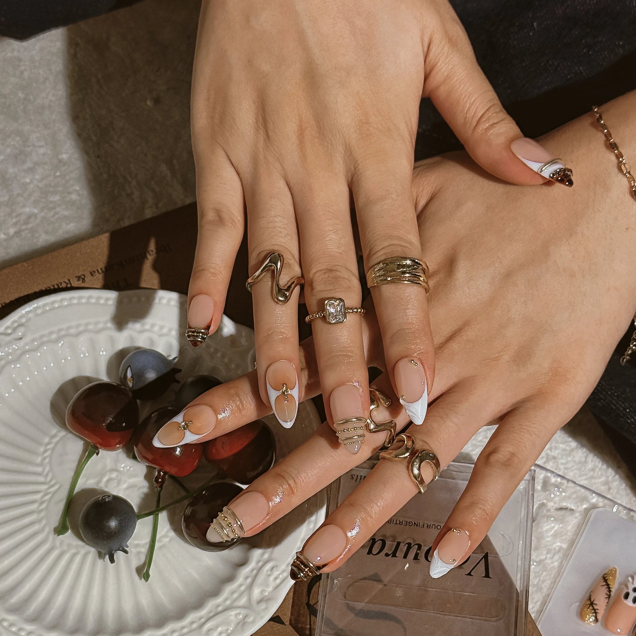 Gilded Tortoise Frame press-on nails worn on both hands in a styled lifestyle setting