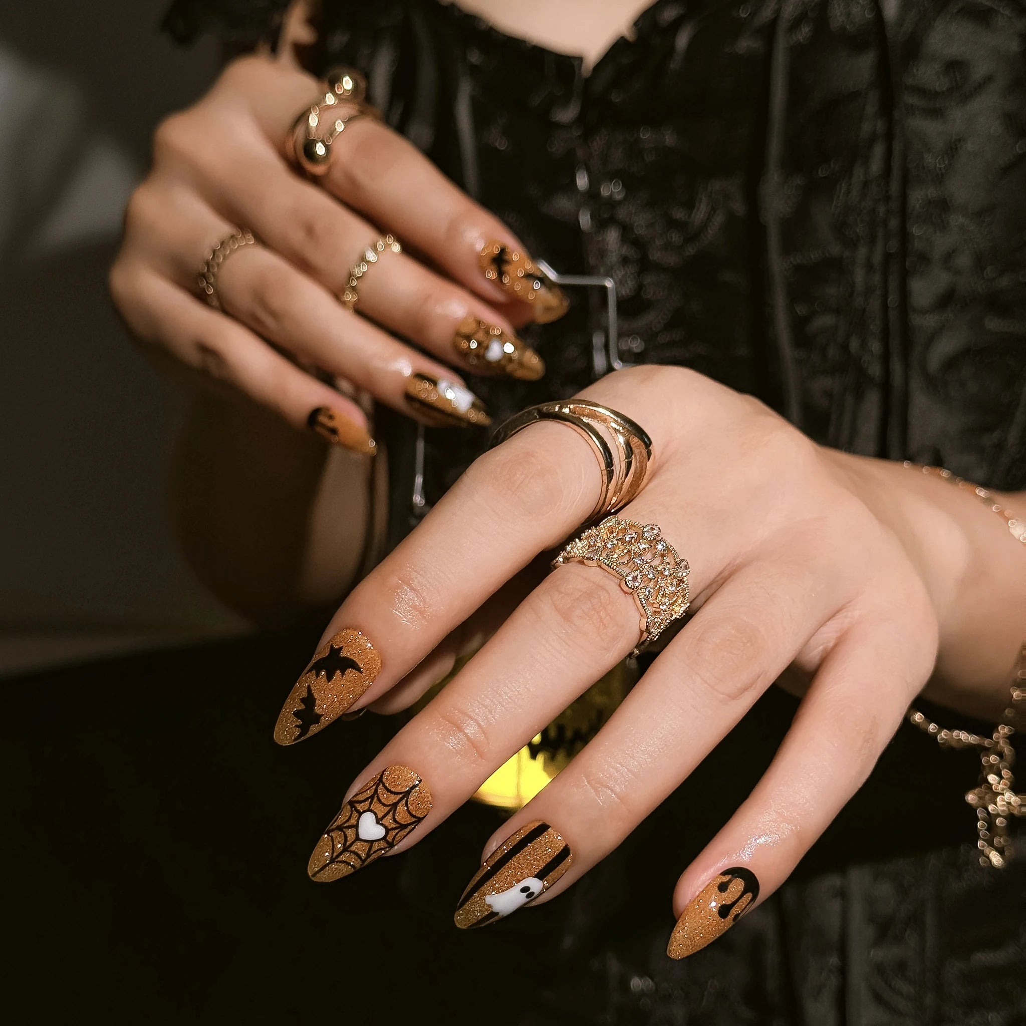 Haunted Amber Web press-on nails worn on both hands in a styled lifestyle setting