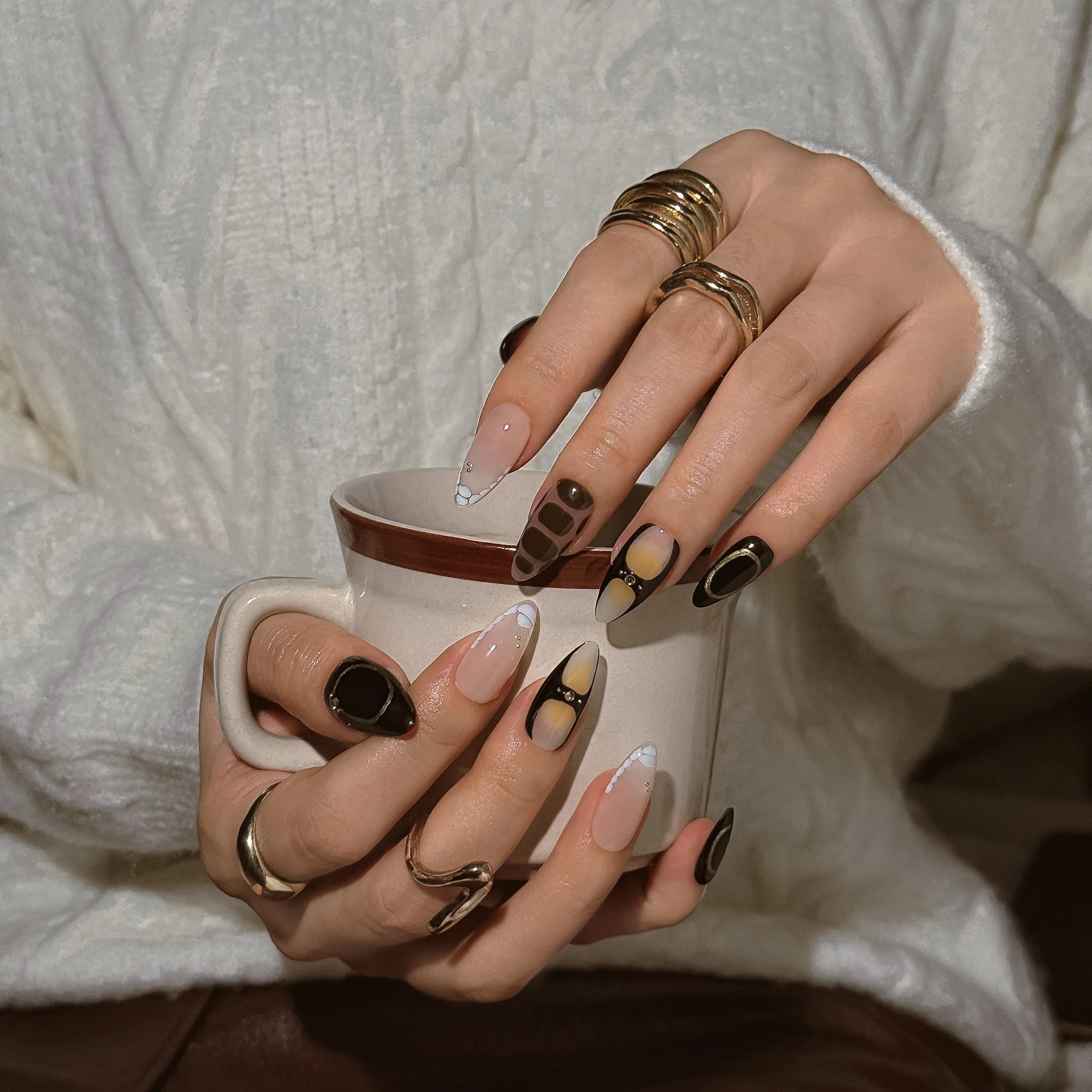 Midnight Mocha Muse press-on nails worn on both hands in a styled lifestyle setting