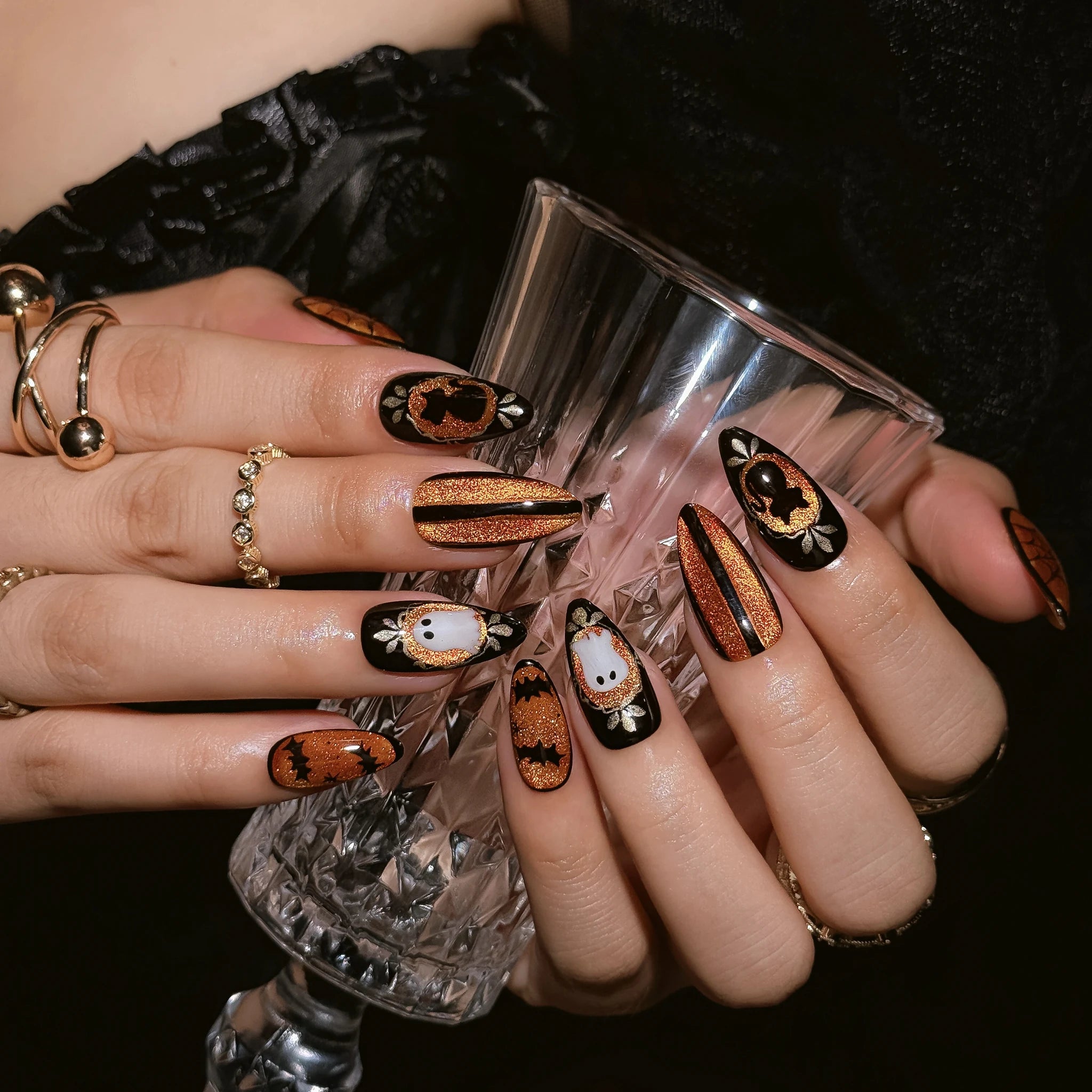 Midnight Pumpkin Portrait press-on nails worn on both hands in a styled lifestyle setting