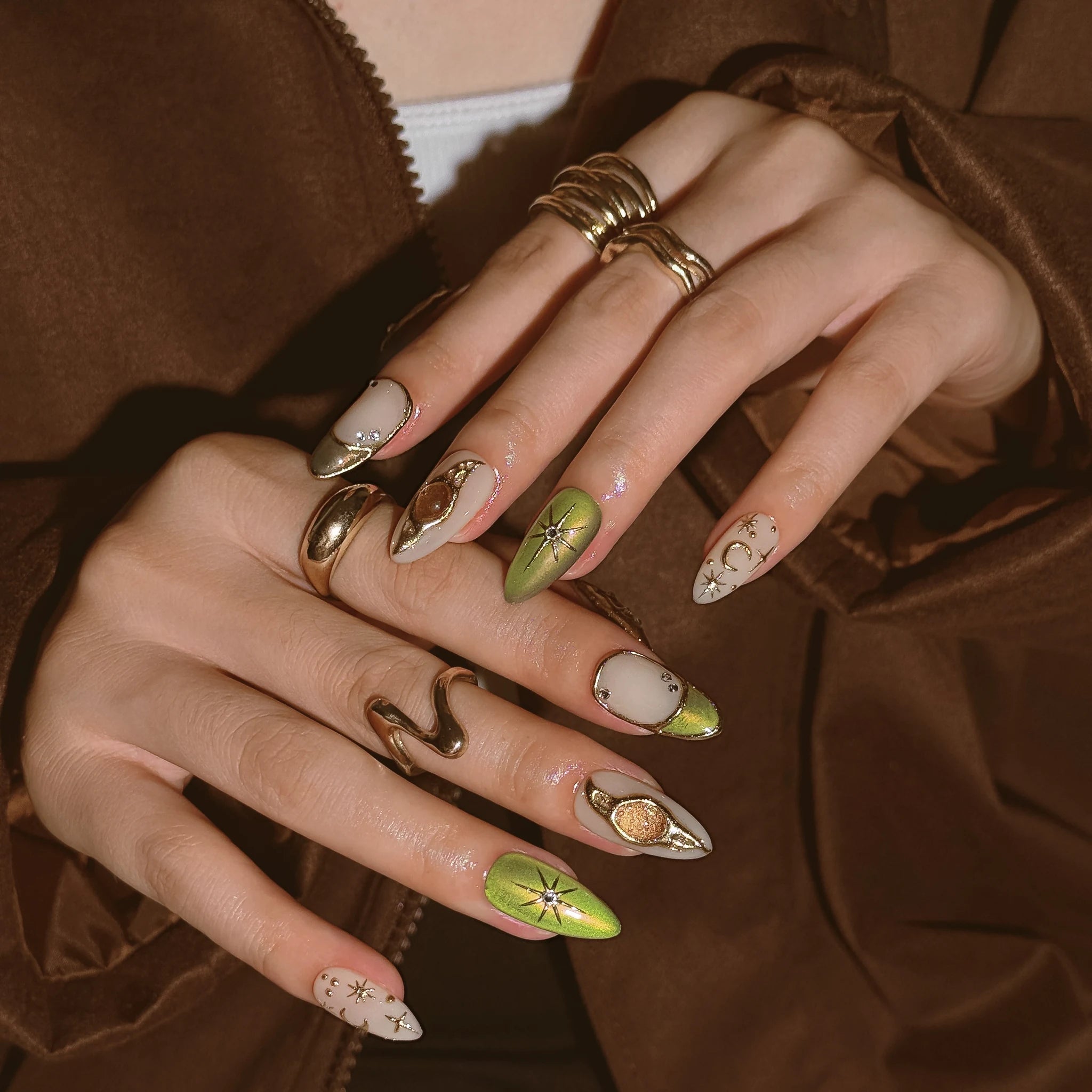 Olive Celestial Relic press-on nails worn on both hands in a styled lifestyle setting