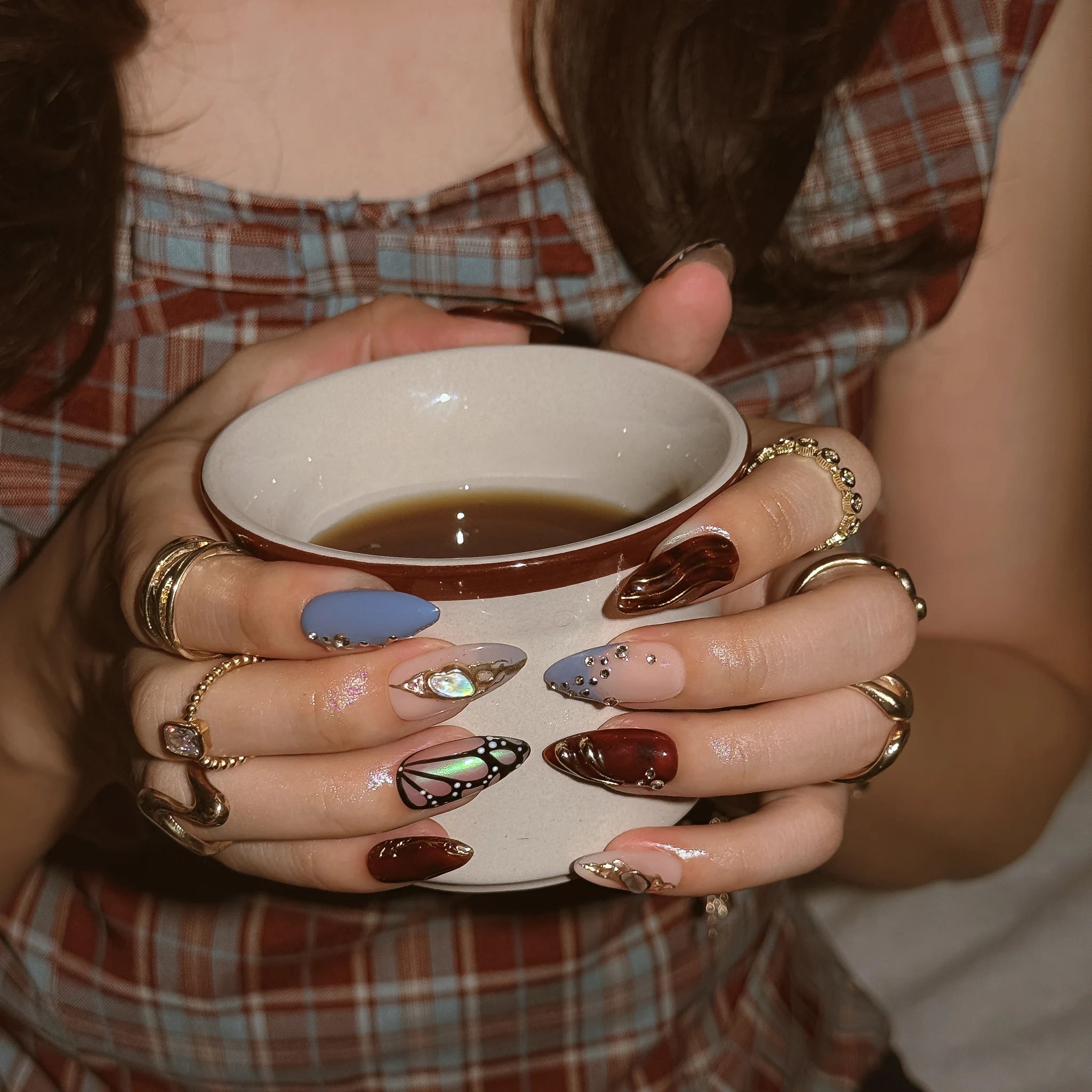 Opal Ember Orbit press-on nails worn on both hands in a styled lifestyle setting