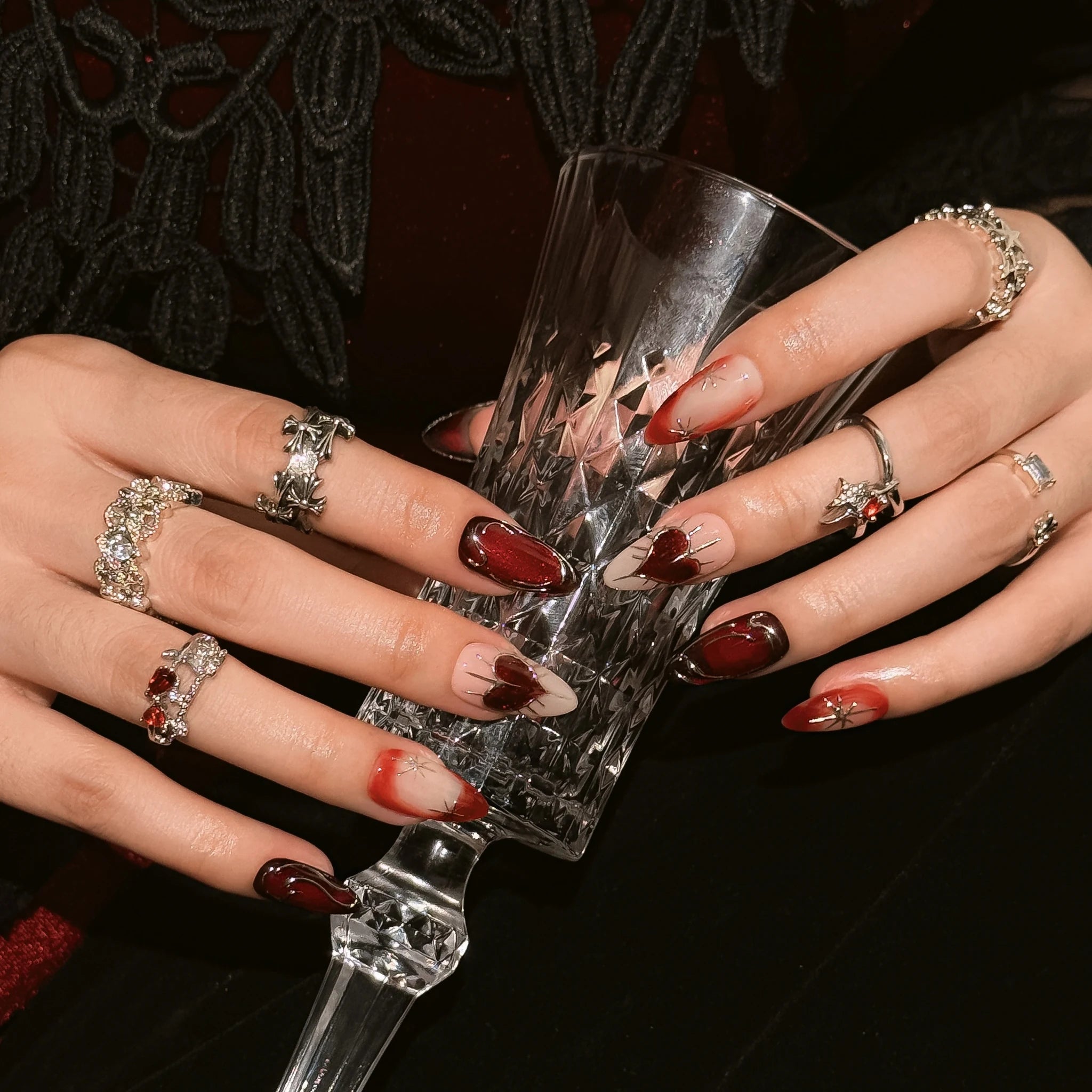 Scarlet Heart Orbit press-on nails worn on both hands in a styled lifestyle setting