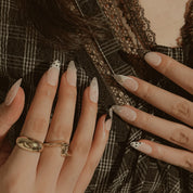 Noir Lace Whisper: hands near a plaid neckline showing nude nails with white dots and black-and-white French tips