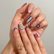 Close-up of Chimera’s Amber Mosaic nails with tortoise patterns, grids, dots, and gold accents.