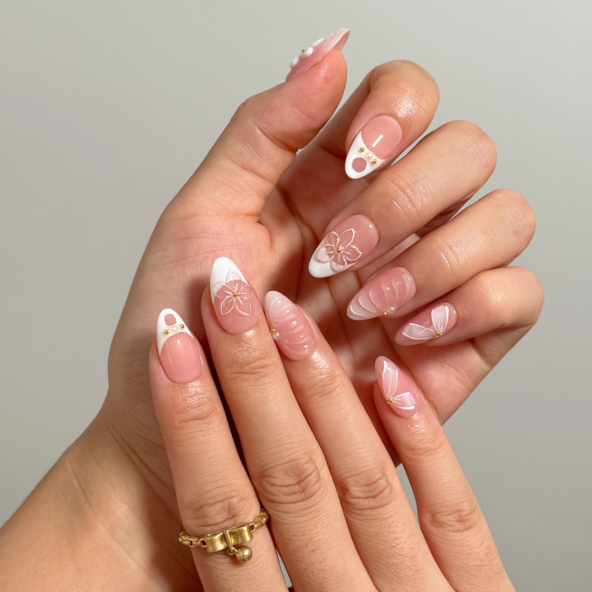 Close-up of Galatea’s Ivory Bloom nails with white French tips, raised flowers, and delicate pink details.