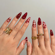 Aphrodite’s Stolen Kiss nail set shown across both hands with glossy red and pink designs.