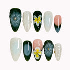 Jade Plumeria Reverie deep green, milky white and nude almond nails with sculpted flowers, yellow centers and pearly accents.