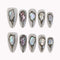 Moonlit Opal Relic press-on nails in ivory and silver with chrome frames, opal-like inlays, and raised 3D details