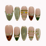 Olive Gilded Mirage press-on nails in nude, olive green, gold, and brown with pearls, crystals, and tortoise-inspired tips