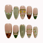 Olive Gilded Mirage press-on nails in nude, olive green, gold, and brown with pearls, crystals, and tortoise-inspired tips