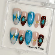 Turquoise Talisman press-on nail set arranged in a Veloura Nails display case