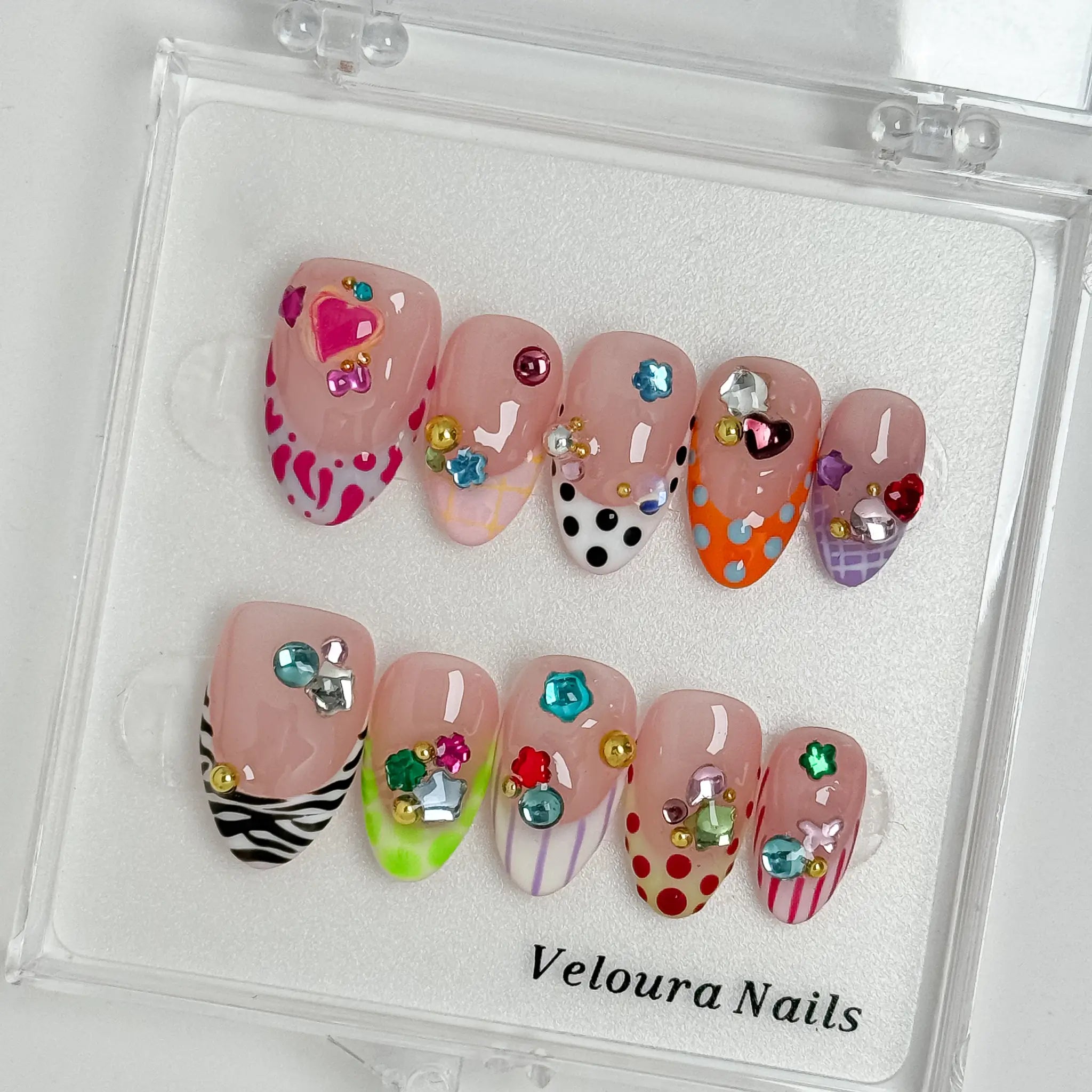 Candy Gem Parade press-on nail set arranged in a Veloura Nails display case