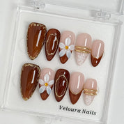 Mocha Blossom Lace press-on nail set arranged in a Veloura Nails display case