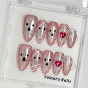 Blushing Phantom Heart press-on nail set arranged in a Veloura Nails display case