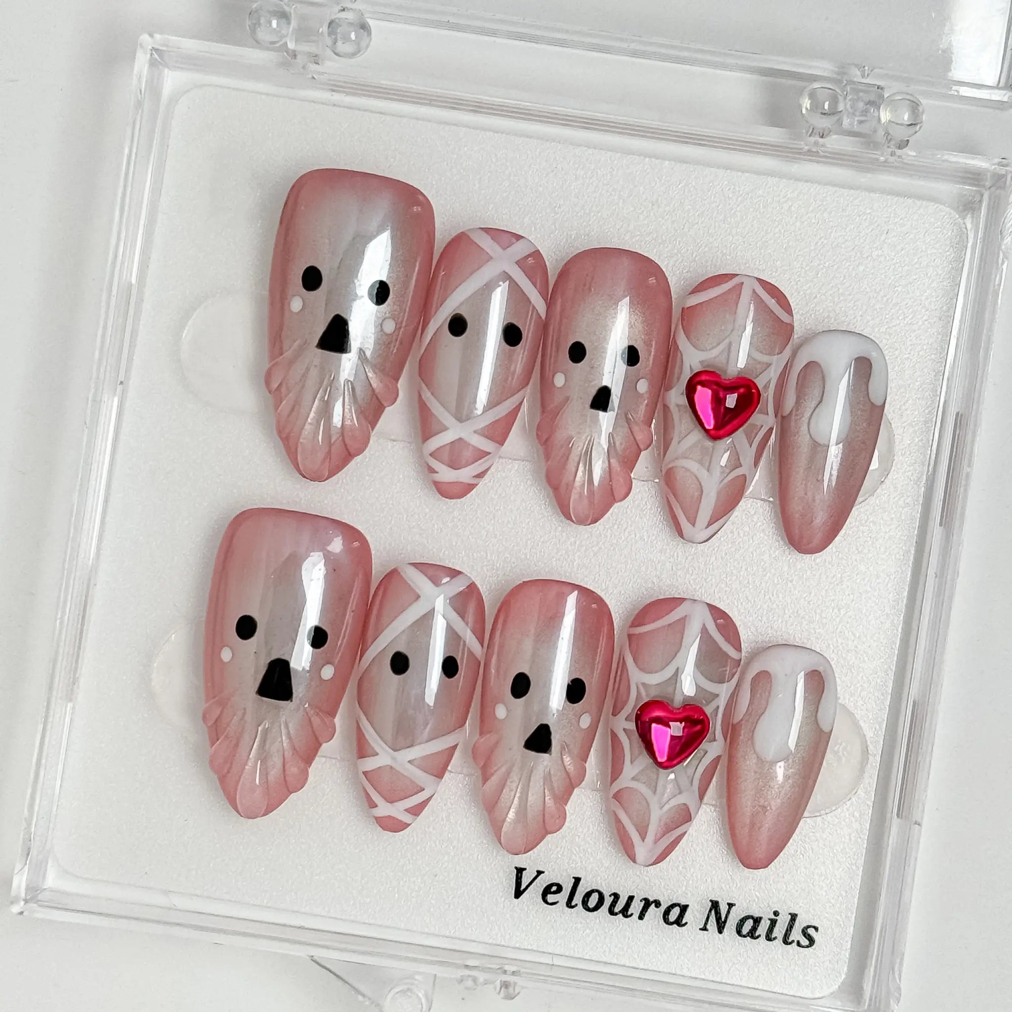 Blushing Phantom Heart press-on nail set arranged in a Veloura Nails display case