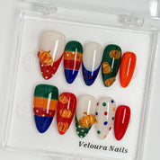 Pumpkin Parade Pop press-on nail set arranged in a Veloura Nails display case