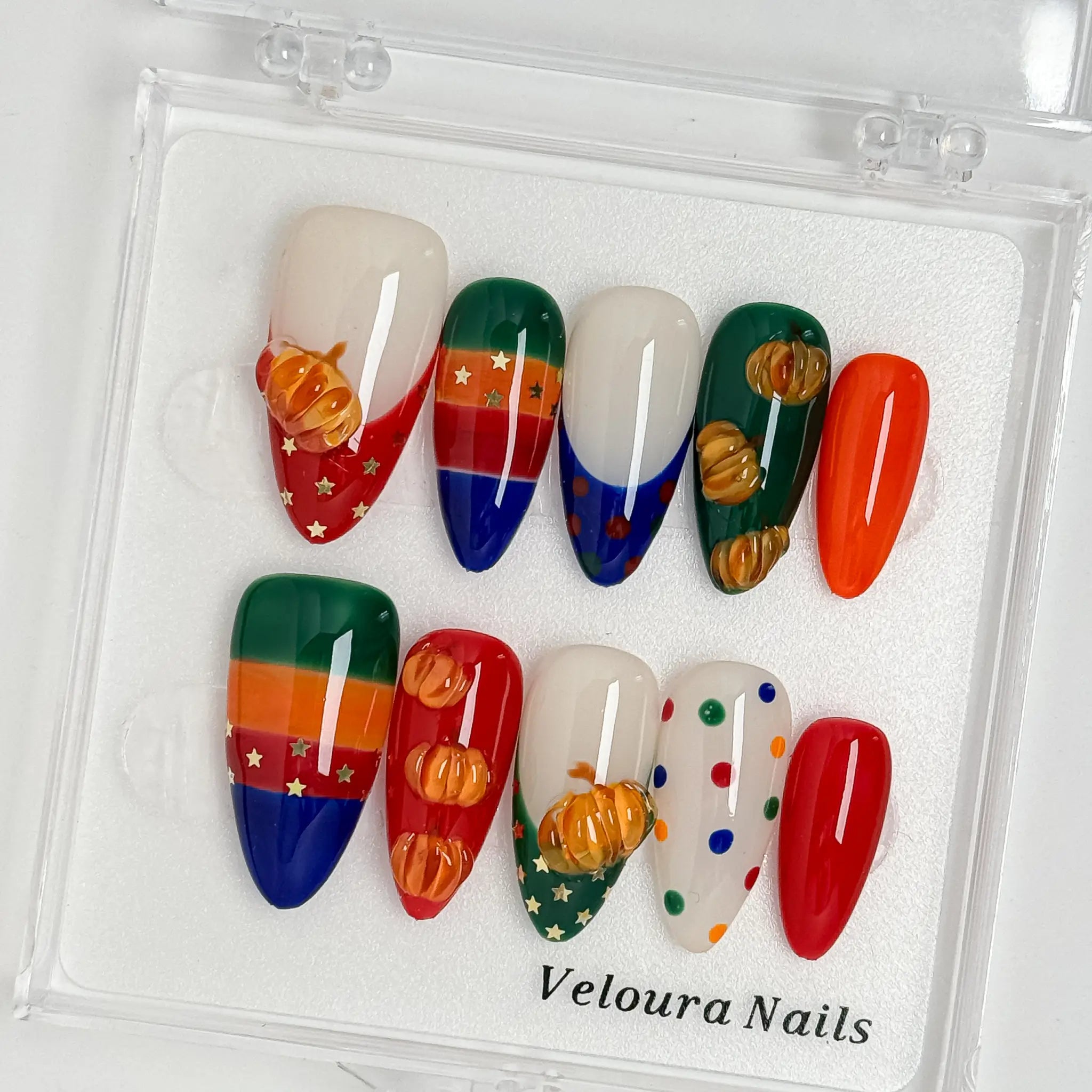 Pumpkin Parade Pop press-on nail set arranged in a Veloura Nails display case