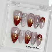 Burgundy Foil Reverie press-on nail set arranged in a Veloura Nails display case
