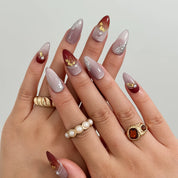 Burgundy Foil Reverie Long Almond press-on nails, modeled detail view 1