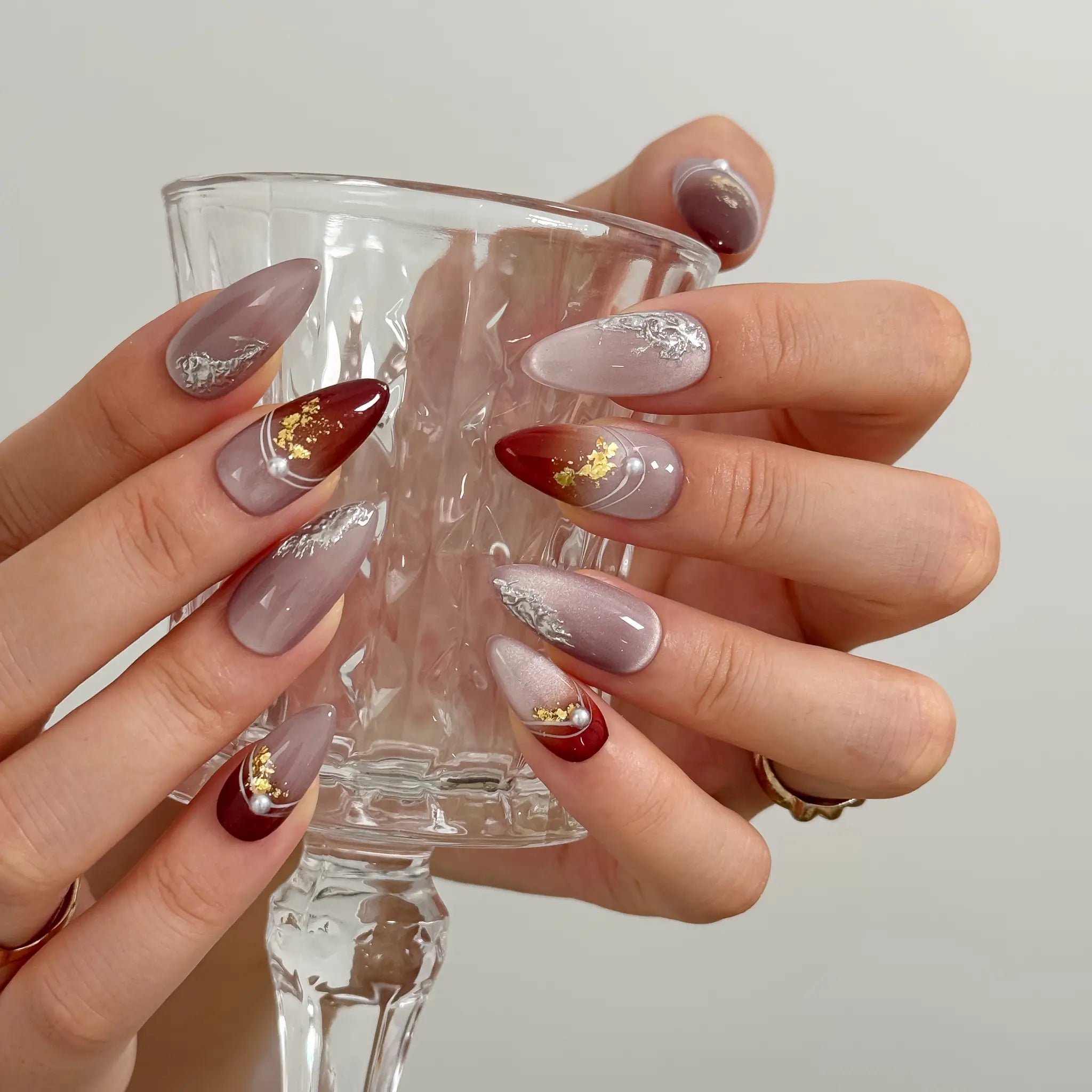 Burgundy Foil Reverie Long Almond press-on nails, modeled detail view 4