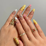 Candy Orbit Charms Long Almond press-on nails, modeled detail view 1