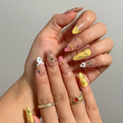 Candy Orbit Charms long almond press-on nails with colorful crystals and gold celestial accents shown on hand