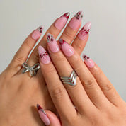 Raspberry Ribbon Trinket press-on nails shown on hand