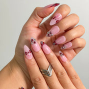 Raspberry Ribbon Trinket Long Almond press-on nails, modeled detail view 1
