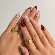 Burgundy Dot Reverie press-on nails shown on hand