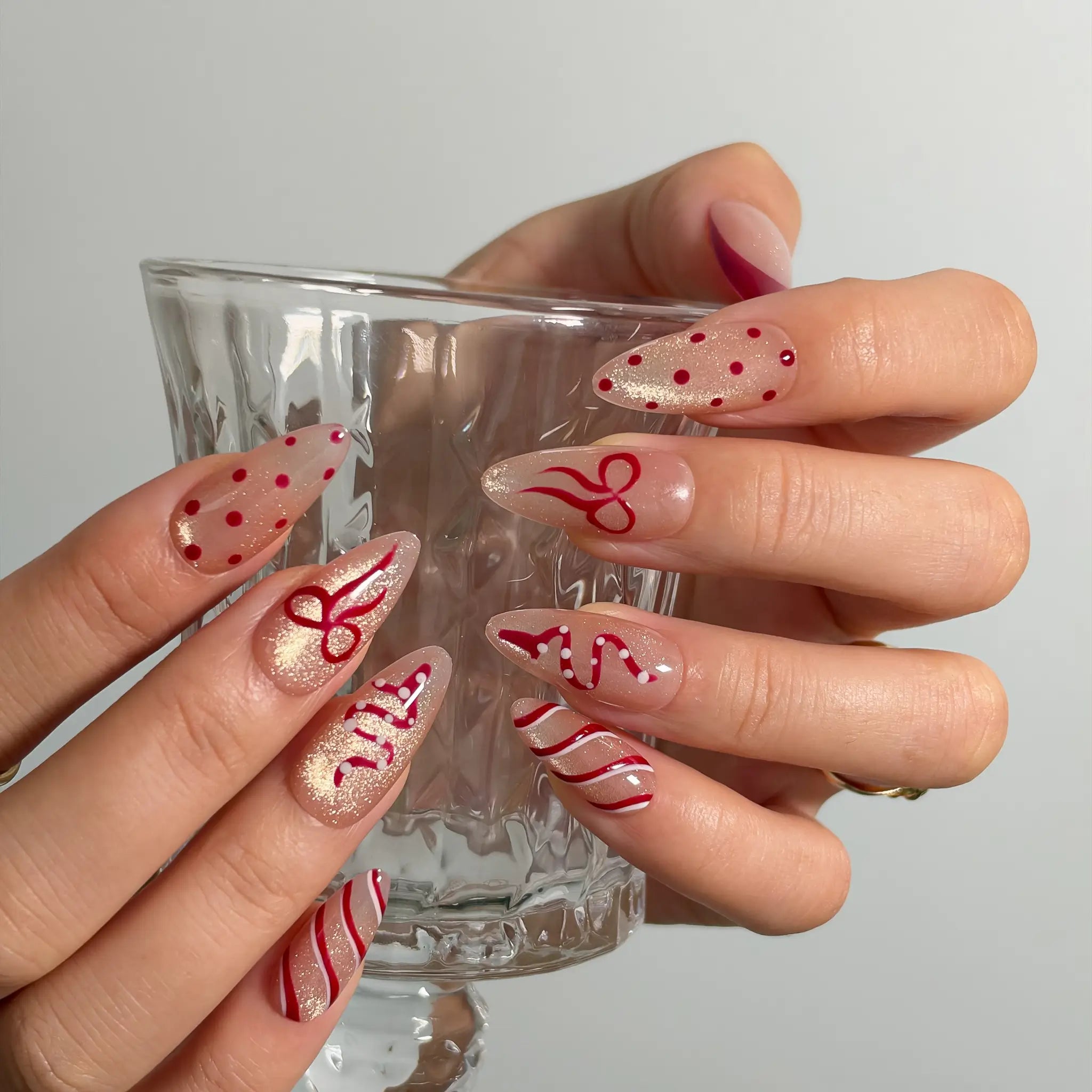 Garnet Ribbon Shimmer Long Almond press-on nails, modeled detail view 2