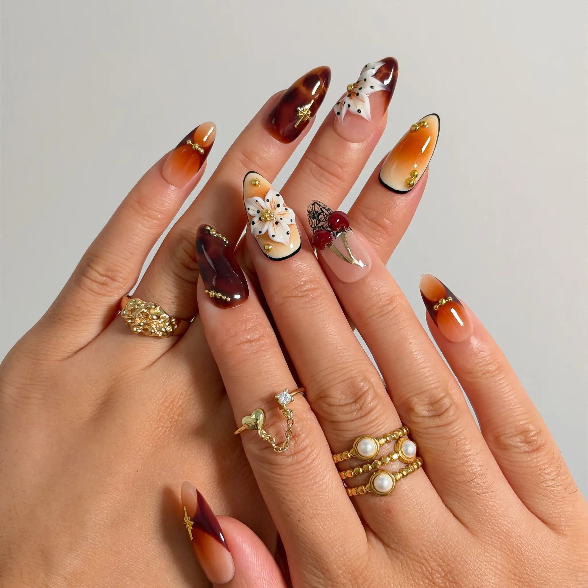 Amber Botanical Heirloom press-on nails shown on hand