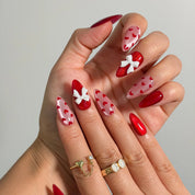 Crimson Heart Parade Long Almond press-on nails, modeled detail view 1